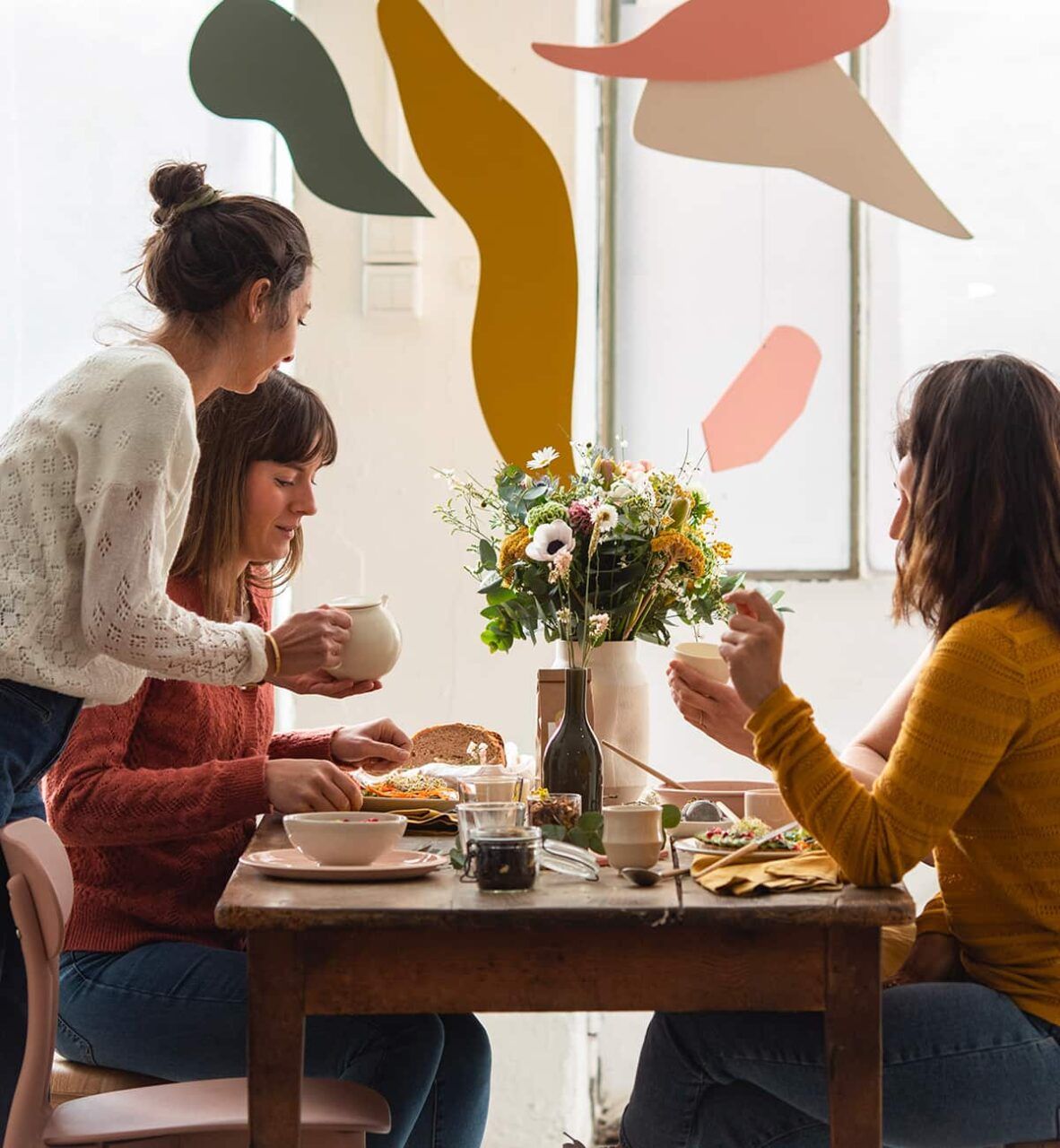 trois filles à table qui prennent un thé