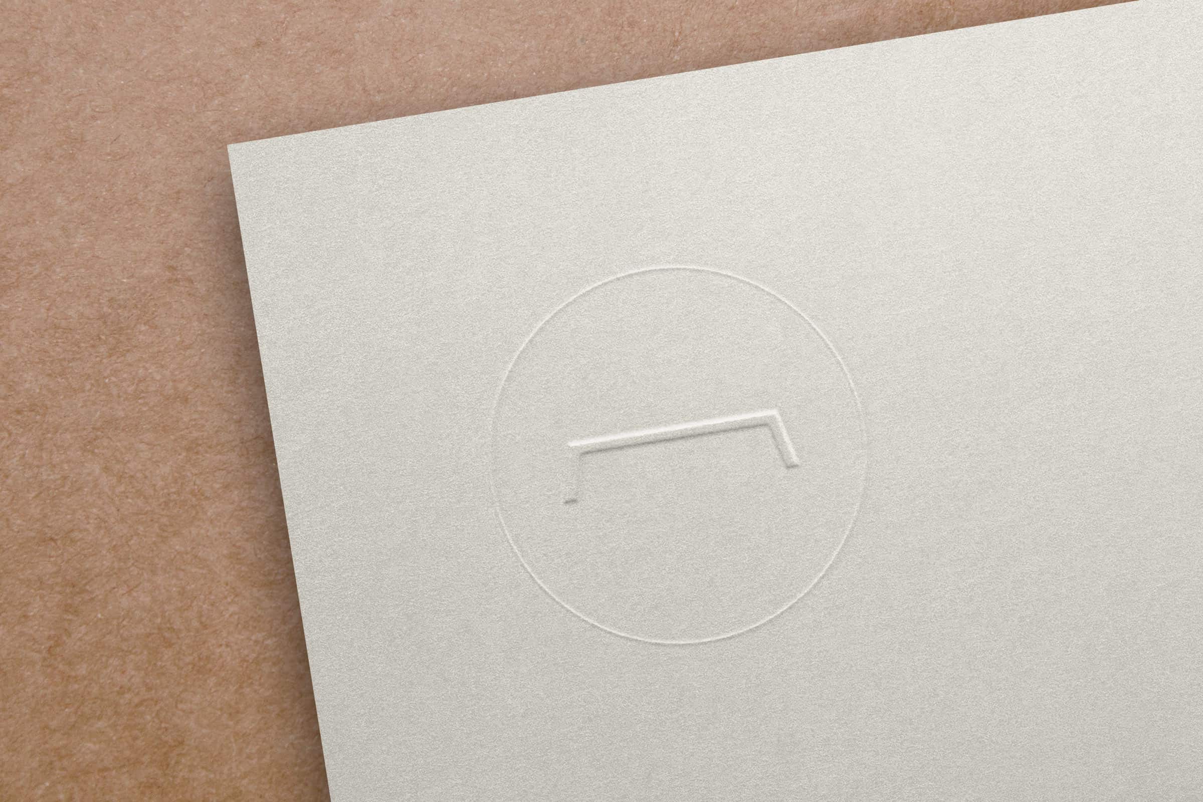monogramme Atelier Emmaüs embossé sur papier blanc